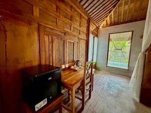 a dining room with a table and a television at Sarini Joglo Villa by Manara in Blahbatu
