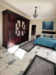 a bedroom with a bed with a blue comforter at Nubian Villa with Private Pool in Naj‘ al Aḩwāl +6 photos