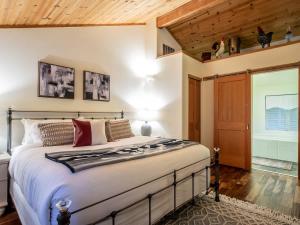 a bedroom with a large bed and a wooden ceiling at Snowline Grand Lodge in Glacier +65 photos