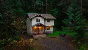 a small white house in the woods at night at Snowline Hillside Chalet in Glacier