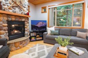 a living room with a couch and a fireplace at Snowline Hillside Chalet in Glacier