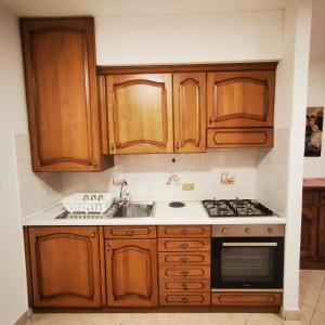 a kitchen with wooden cabinets and a sink at Casa MEME' in Santa Maria Maggiore +5 photos