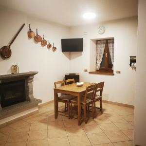 a dining room with a table and a fireplace at Casa MEME' in Santa Maria Maggiore