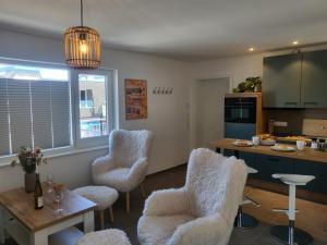 a kitchen with white chairs and a table and a counter at Haus Eintracht Appartment 3 in Sankt Peter-Ording