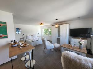 a living room with a couch and a table and chairs at Haus Eintracht Appartment 3 in Sankt Peter-Ording