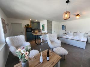 a living room with a bed and chairs and a table at Haus Eintracht Appartment 3 in Sankt Peter-Ording