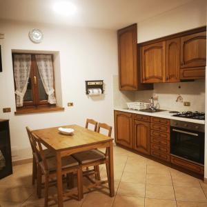 a kitchen with wooden cabinets and a table and chairs at Casa MEME' in Santa Maria Maggiore