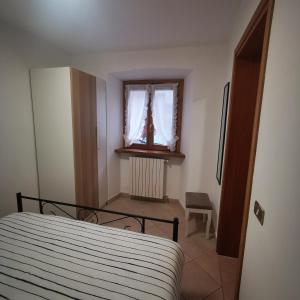 a bedroom with a bed and a window at Casa MEME' in Santa Maria Maggiore