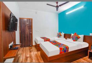 a room with two beds and a flat screen tv at RLV green palace in Bangalore