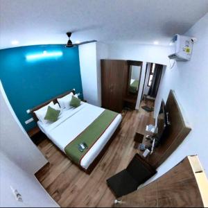 a bedroom with a large bed and a blue wall at RLV green palace in Bangalore +3 photos