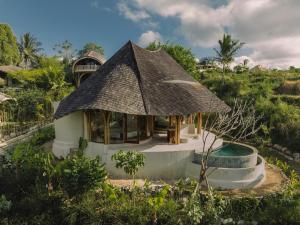 a house with a thatched roof and a pool at Mandala Eco Resort Lombok in Selong Belanak