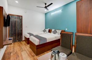 a bedroom with a bed with a ceiling fan at RLV green palace in Bangalore