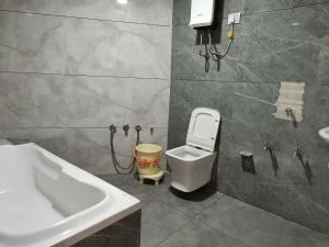 a bathroom with a tub and a toilet and a sink at Hotel New Vinay in Kapadvanj +18 photos
