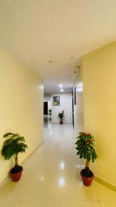 a hallway with two potted plants in a building at Hotel New Vinay in Kapadvanj