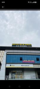 a building with a sign on the top of it at Hotel New Vinay in Kapadvanj
