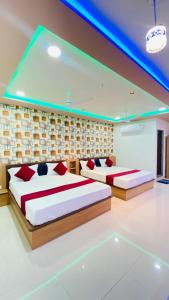 two beds in a room with blue lights at Hotel New Vinay in Kapadvanj