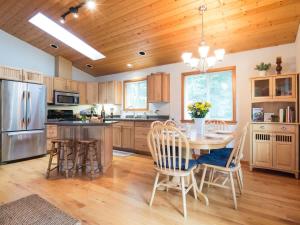 a kitchen with a table and chairs and a refrigerator at Woodland Bungalow in Glacier