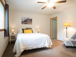 a bedroom with a bed and a ceiling fan at Woodland Bungalow in Glacier