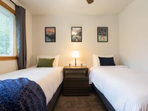 two beds sitting next to each other in a bedroom at Woodland Bungalow in Glacier +9 photos