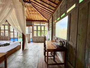 a bedroom with a bed and a table in a room at Sarini Joglo Villa by Manara in Blahbatu
