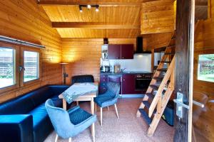 a living room with a couch and a table and a kitchen at Ferienwohnung Reimann in Loddin +12 photos