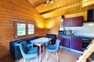 a kitchen with a couch and a table and chairs at Ferienwohnung Reimann in Loddin