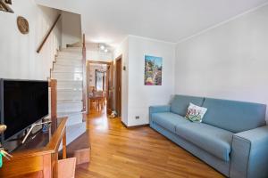 a living room with a blue couch and a television at Maison Rosamunda - Happy Rentals in Oulx