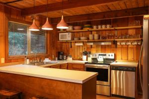 a kitchen with wooden cabinets and a stove top oven at Sweet Seclusion in Glacier