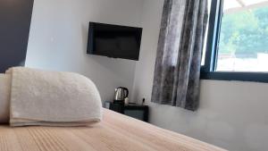 a bedroom with a bed with a tv and a window at Arsuz Suite House in Arsuz +1 photo