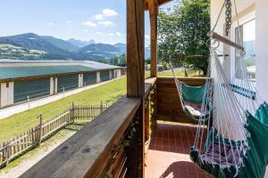 a porch with a hammock and a view at Pferdeblick Hütte auf der Rodeoranc in Rottenmann