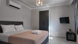 a bedroom with a bed and a tv on the wall at Arsuz Suite House in Arsuz