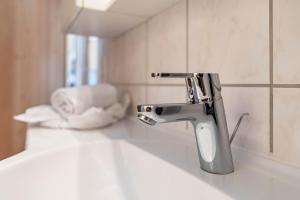 a bathroom sink with a faucet and a mirror at Pferdeblick Hütte auf der Rodeoranc in Rottenmann +23 photos