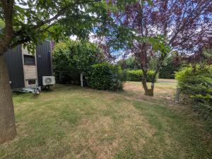 a backyard with a tiny house and trees at Rosemont Retreat by Tiny Away in Bessé-sur-Braye
