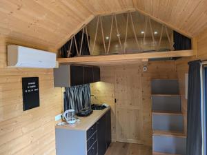 a kitchen in a tiny house with wooden walls at Rosemont Retreat by Tiny Away in Bessé-sur-Braye +11 photos