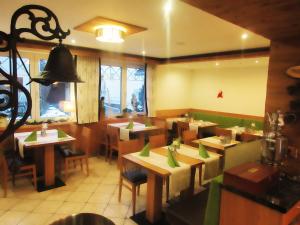 jadalnia ze stołami i krzesłami w restauracji w obiekcie Pension Wachau w mieście Klagenfurt