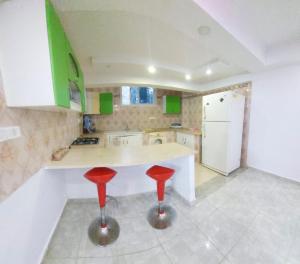 a kitchen with a counter and two red stools at Hammamet sunrise in Hammamet
