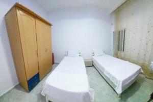 a room with two beds and a wooden cabinet at Hammamet sunrise in Hammamet