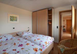 ein Schlafzimmer mit einem Bett mit geblümter Bettdecke in der Unterkunft Erlebnishof Katthusen in Otterndorf