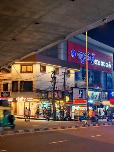 a city street at night with a building at Trio Rooms & dormitory in Trivandrum
