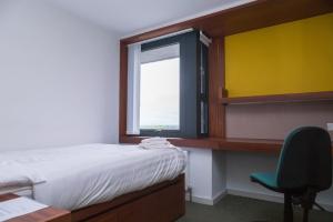 een slaapkamer met een bed, een bureau en een raam bij The Quigley Residence in Limerick
