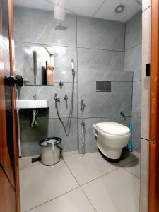 a bathroom with a shower and a toilet and a sink at Trio Rooms & dormitory in Trivandrum