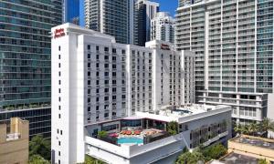 a large white building with a pool in front of tall buildings at Hampton Inn & Suites by Hilton Miami Downtown/Brickell in Miami
