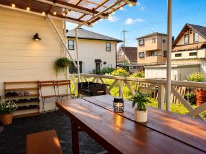 a wooden table on a patio with a fence at Daiwa House BBQ 琵琶湖徒步3分 無料駐車4台プロジェクター in Takashima