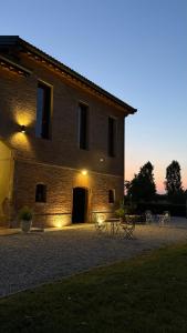 a building with tables and chairs in front of it at Casa Tarabuso B&B in Reggio Emilia