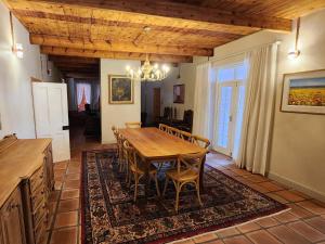 a dining room with a wooden table and chairs at Maskam Manor in Vanrhynsdorp