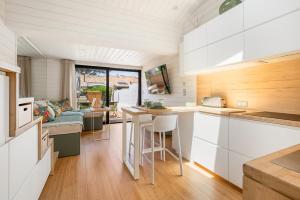 a kitchen with white cabinets and a living room at Villa 52 Naturiste in Cap d'Agde