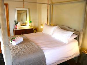 a bedroom with a large white bed with a mirror at Maskam Manor in Vanrhynsdorp