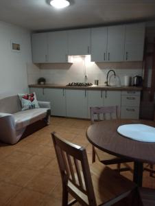 a kitchen and living room with a table and a couch at Domki pod brzózkami in Bodzentyn