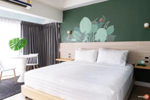a bedroom with a white bed and a green wall at Bangkok Sleep Nest in Sathani Ban Hua Mak +16 photos