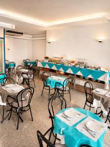 a dining room with tables and chairs and a buffet at Hotel Alb's in Alba Adriatica
